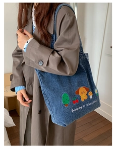 Detail of blue washed denim tote bag with colorful animal and nature park embroidery