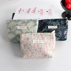 Detailed close-up of three floral canvas cosmetic bags with metal zippers and jacquard texture