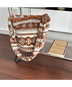 Detail of plush brown and white bucket bag with snowflake and diamond patterns
