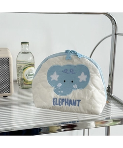 Close-up of a white quilted shell-shaped pouch with blue elephant patch embroidery