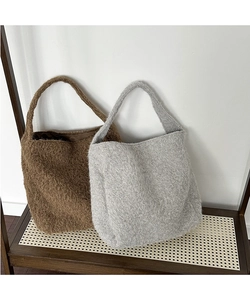 Detailed texture of fuzzy wool bucket bags in caramel brown and light grey colors