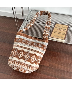 Detail of plush bucket bag featuring geometric knit patterns in brown and grey tones