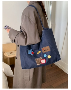Close-up of retro denim tote bag featuring colorful star patches and letter embroidery