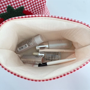 Interior view of red checkered makeup bag showing large capacity with skincare items
