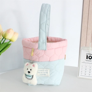 Detailed quilted texture on a pink and blue tote bag featuring a cute teddy bear charm