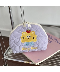 Close-up of heart quilted purple makeup bag featuring embroidered King Lion and bear zipper