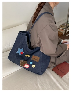 Close-up of vintage denim tote bag featuring retro patches, star appliques and embroidery