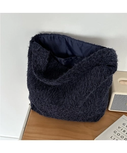 Detail view of the deep blue wool bucket bag showing inner lining and interior pocket