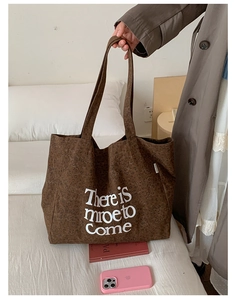 Detail of canvas tote bag with brown leopard print and bold white lettering on side