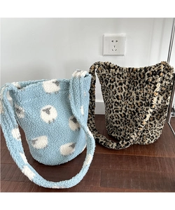 Detail of plush bucket bags in leopard print and blue sheep pattern with soft wide straps