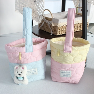 Detail of quilted cotton bucket bag with cloud patterns and plush bear charm