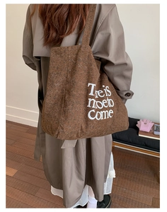Detailed view of large leopard print canvas tote bag with white text on a model's shoulder