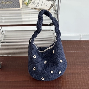 Detaillierte Textur der blauen Plüsch-Hobo-Tasche mit weißen 3D-Gänseblümchen-Stickereien