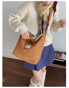 Detail of brown suede crossbody bag with soft white faux fur lining and drawstring closure