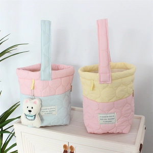 Detail of cute quilted cloud bucket bags with plush bear charms and contrast color handles
