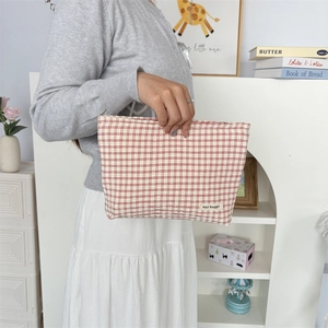 Detail van rood-wit geruite stoffen make-uptas met het May Rabbit-label