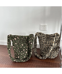 Detail of plush leopard print tote bags in green and brown showing soft fuzzy texture