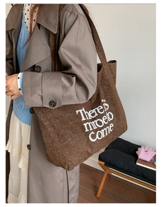 Detail of large brown leopard print canvas tote bag with 'There is mroe to Come' text