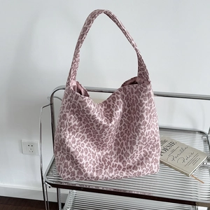 Pink leopard print tote bag with large capacity displayed on a modern metal shelf
