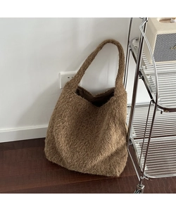 Close-up of brown shaggy tote bag showing fuzzy wool-like texture and warm caramel tone