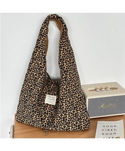 Detail of leopard print tote bag with woven label on vintage wooden surface