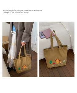 Detail of khaki canvas tote with embroidered cartoon dog and breathing in nature park text