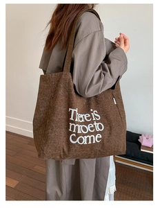 Close-up of brown leopard print canvas tote bag with bold white artistic slogan print
