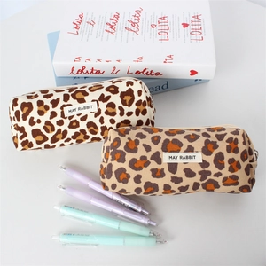 Detail of leopard print canvas makeup bags with zippers and woven MAY RABBIT brand tags