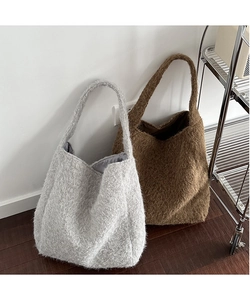 Detailed texture of fuzzy wool bucket bags in grey and brown for autumn winter style
