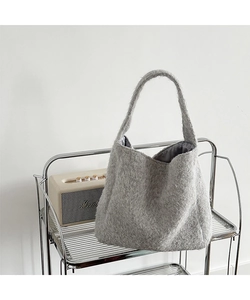 Detail of light grey faux fur texture and satin lining on a large shoulder bucket bag