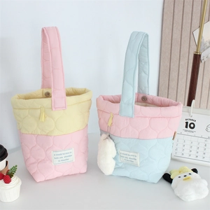 Detail of quilted cloud bucket bag with magnetic closure and soft padded handle