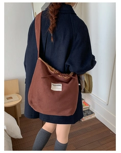 Close-up of brown suede tote bag with fleece lining and white SEEYOU woven label