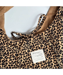 Close-up of vintage corduroy leopard print tote bag with embroidered magazine text label