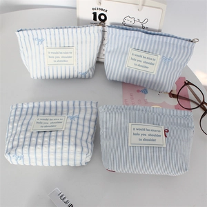 Blue and white embroidered bow makeup pouch with striped and plaid patterns