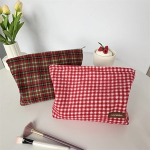 Détail de trousses à maquillage en tweed à carreaux avec fermeture éclair et texture