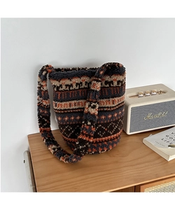 Detail of plush bucket bag featuring ethnic prints and soft fleece texture with printed strap