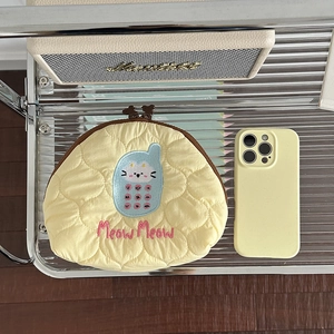Lemon yellow quilted cosmetic bag with cute cat embroidery on a metal display stand