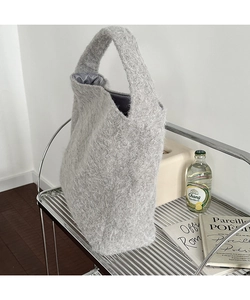 Close-up of grey plush wool bucket bag texture with smooth satin lining and soft fiber detail