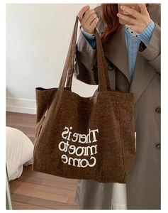 Detail view of large brown leopard print tote bag with white text on heavy canvas