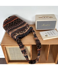 Close-up of plush tote bag featuring geometric patterns in warm orange and brown tones