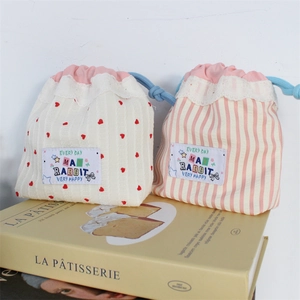 Close-up of cute lace drawstring pouches with heart patterns and striped fabric detail