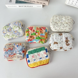 Detail view of assorted quilted floral coin purses with metal zippers and cute bear patterns