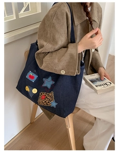 Close-up of vintage denim tote bag featuring retro patches and star motifs details