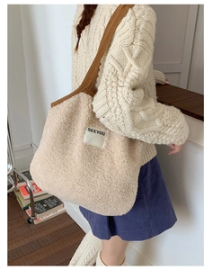 Detail of plush off-white tote bag with brown knit strap and SEEYOU label on wool fabric