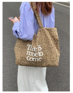 Detail of canvas tote bag with leopard print and There Is More To Come text design