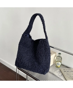 Detail showing the fluffy dark faux fur texture and large capacity of this soft tote bag