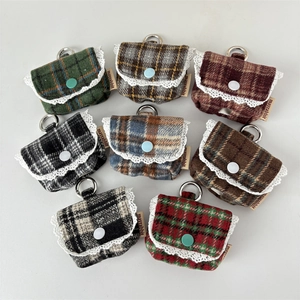 Detailed close-up of plaid tweed earphone cases with lace trim and metal D-rings