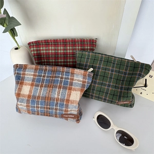 Lot de trois trousses à maquillage vintage en tweed épais présentées dans un décor lifestyle