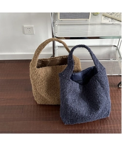 Detail view of large fuzzy wool bucket bags in coffee and navy for winter commute