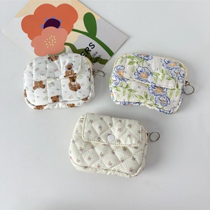 Detailed view of quilted cotton coin purses with floral patterns and zipper closures